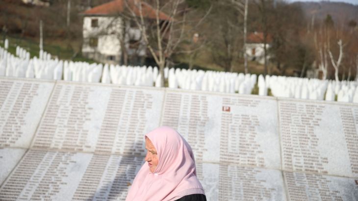 A woman walks past the Memorial plaque with the names of people killed in the Srebrenica massacre at the Memorial centre Potocari near Srebrenica