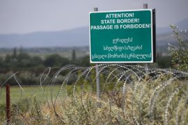 A warning sign is pictured behind a wire barricade erected by Russian and Ossetian troops along Georgia''s de-facto border with its breakaway region of South Ossetia in the village of Khurvaleti