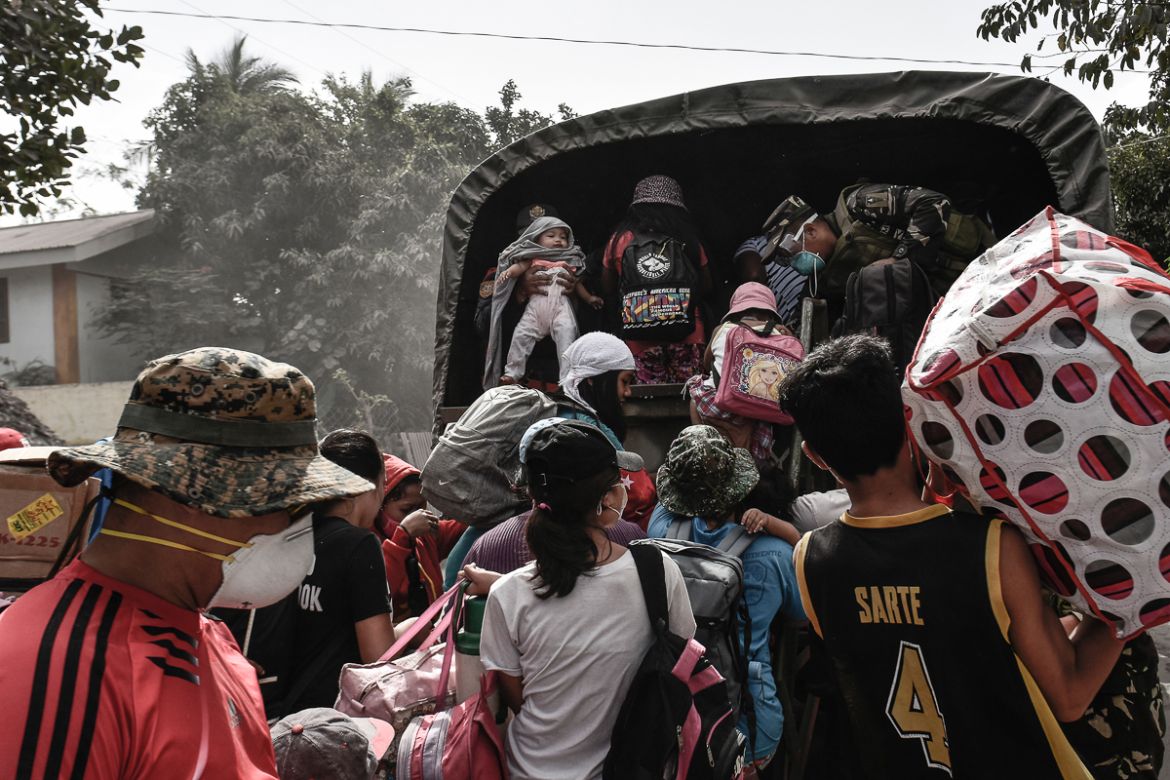 Residents flock to board a military truck as they flee the nine kilometer extended danger zone around Mount Mayon in Guinobatan, Albay province, Philippines, January 23, 2018.