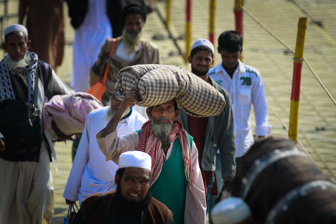 Muslim devotees carry their belongings as they arrive at the Biswa Ijtema Turag in Tongi. [Mahmud Hossain Opu/Al Jazeera]