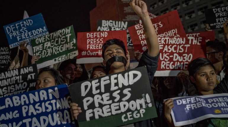 Filipinos Protest Against Orders For News Site Rappler To Close with signs that read 'Defend Press Freedom'.