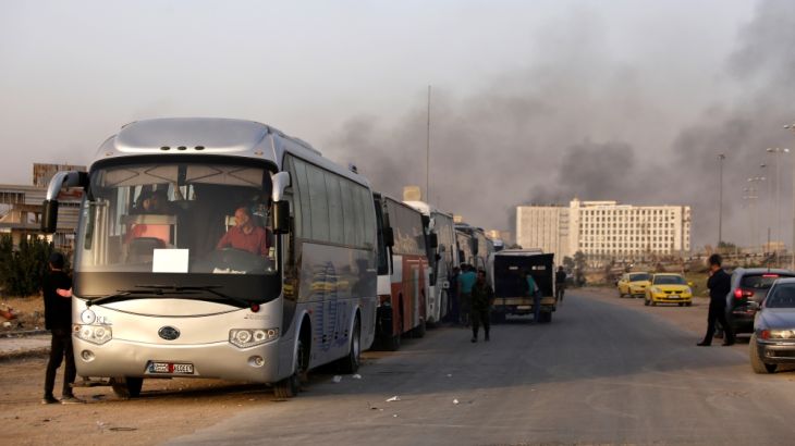 A convoy of buses that carry rebels and their families waits at Harasta highway outside Jobar