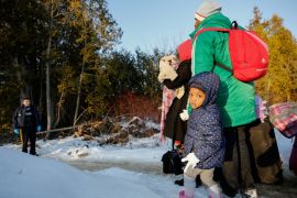 A girl waits with her family before crossing the US-Canada border into Canada in Champlain