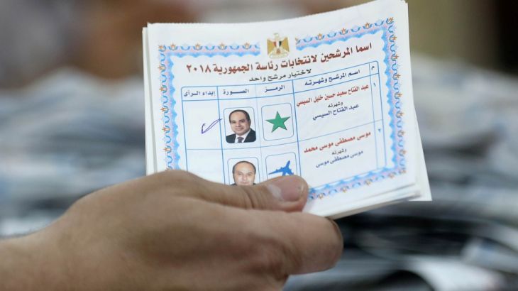Electoral worker displays a ballot after polls closed during the presidential election in Cairo