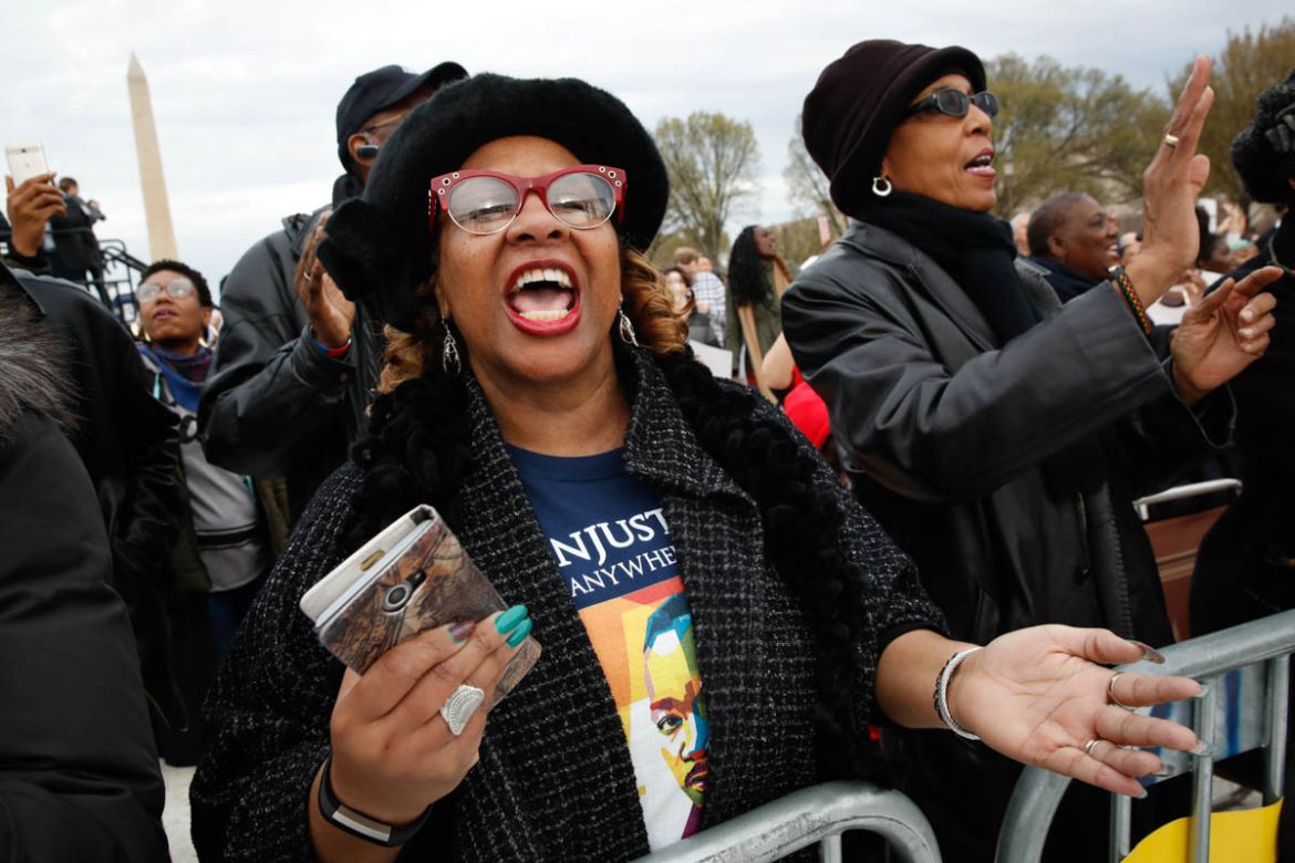Wearing a t-shirt of Martin Luther King, Jr., Debra Payne, of Kansas City, Missouri, sings "This Little Light of Mine," next to Jo-Lynn Gilliam, of East Point, Ga., as they attend the A.C.T. To End Ra
