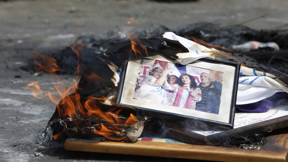 A framed photograph that shows Rosario Murillo, second from right, the first lady and vice president of Nicaragua, set on fire by protesters, burns during clashes with riot police in the Monimbo district of Masaya [Alfredo Zuniga/AP]