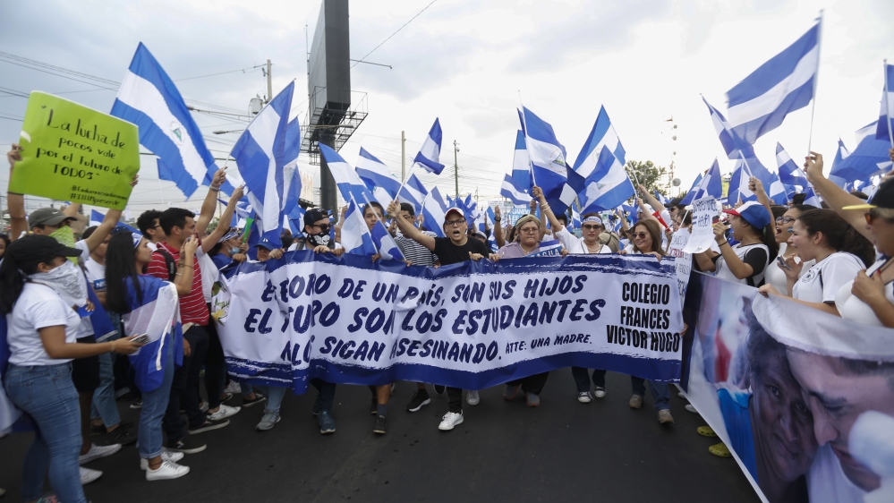 People carry a banner that reads in Spanish, 'The future of a country is its children. The future is students. Stop killing them' during a protest at the Jean Paul Genie roundabout against the government of President Daniel Ortega, in Managua [Alfredo Zuniga/AP]