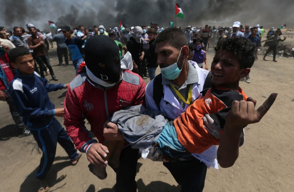 A wounded Palestinian boy is evacuated during a protest against U.S. embassy move to Jerusalem and ahead of the 70th anniversary of Nakba, at the Israel-Gaza border in the southern Gaza Strip May 14,