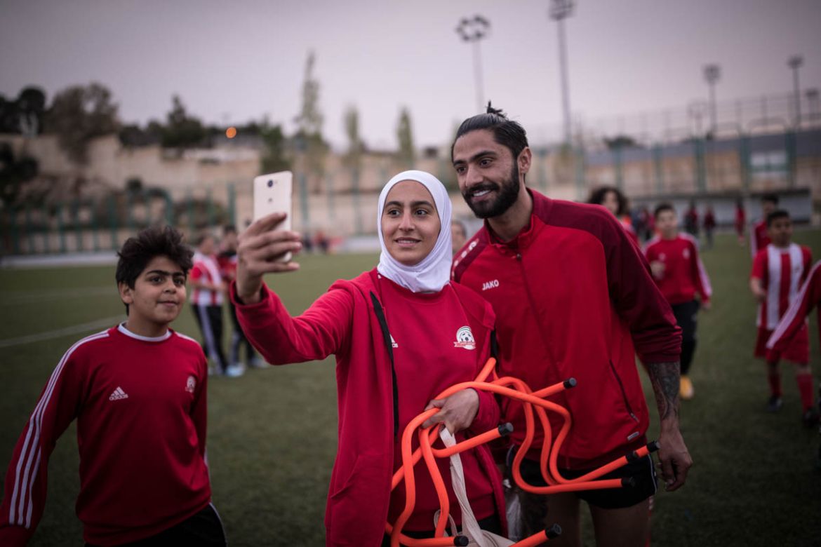 One of the girls playing for the U-15 team at the Shebab Al Ordon Club is taking a selfie with one of the players of the team’s senior team whose training sessions precede the girls’.