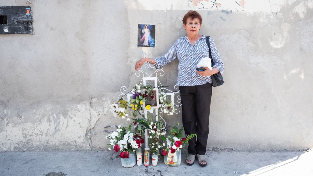 Taide Elena, 68, stands next to the cross where her grandson was killed. [Eline van Nes/Al Jazeera] 