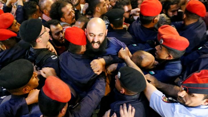 Policemen clash with protesters near the Jordan''s Prime Minister''s office in Amman