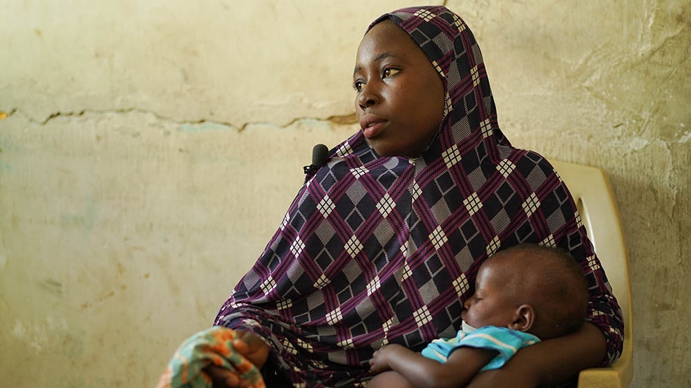 Yagana and her child, sitting in one of the offices in the NYSC IDP camp in Maiduguri [Joi Lee/Contrast VR]
