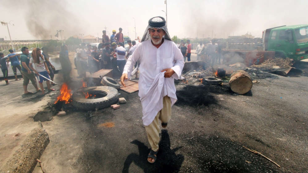 Protesters burned tires and blocked the road leading to the city of Basra on Thursday [Essam al-Sudani/Reuters]