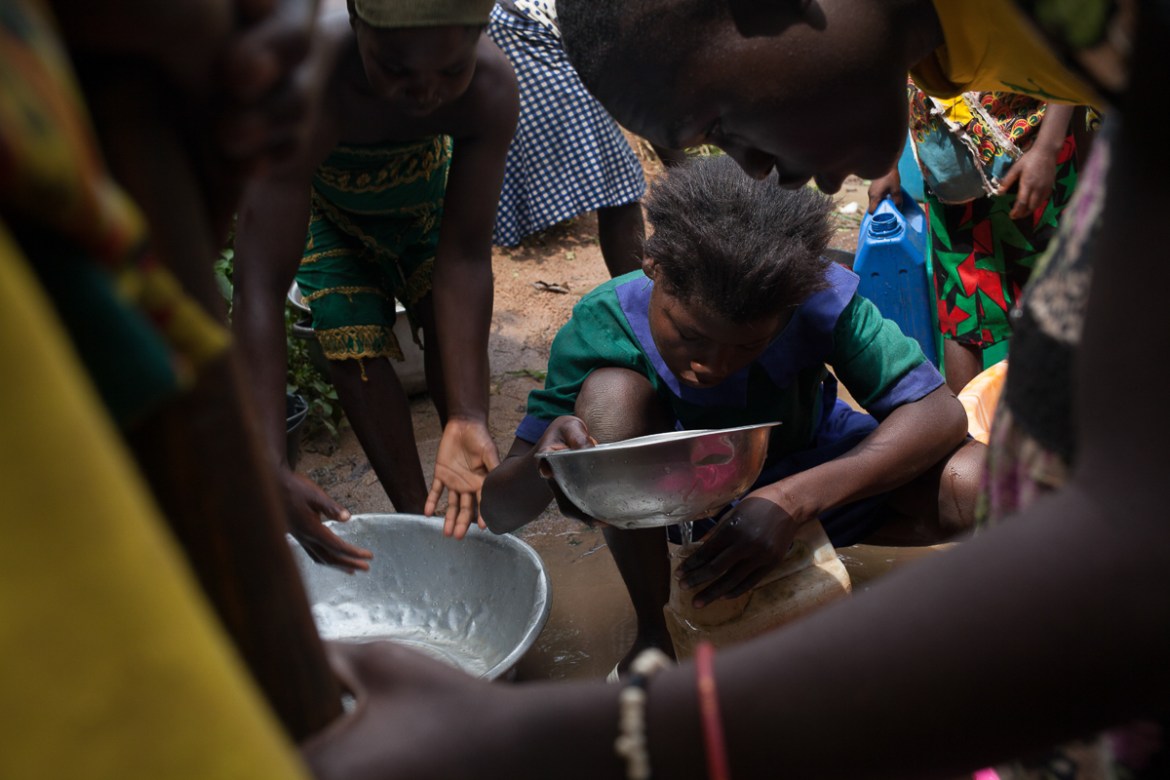Kids fill buckets of water in Bombe Chateau, Cameroon. The village’s only well, built by an NGO, broke down so they have to wait hours in line at the water source to collect from the thin flow of clea