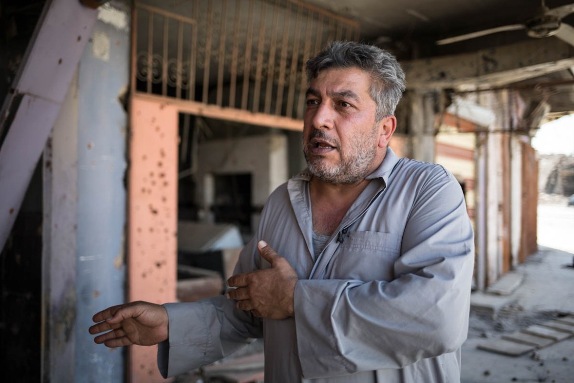 Photo 14 A man speaks out in front of what is left of his shop. Taha was the owner of a sound recording studio is currently jobless in West Mosul. “ISIS confiscated the recording devices from my studi