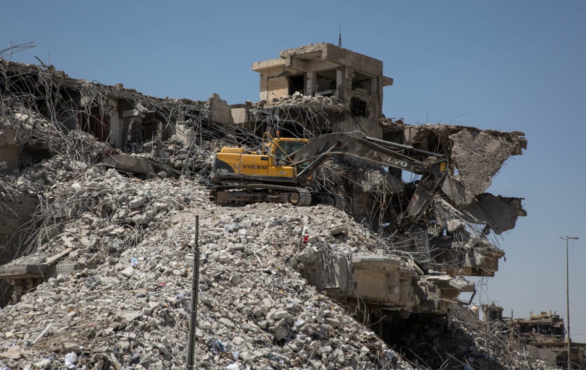 Photo 15 and 16 A bulldozer demolishes the remains of a building in west Mosul. Clearing operations have started recently but the scale of the work that needs to be done is immense and the Iraqi autho