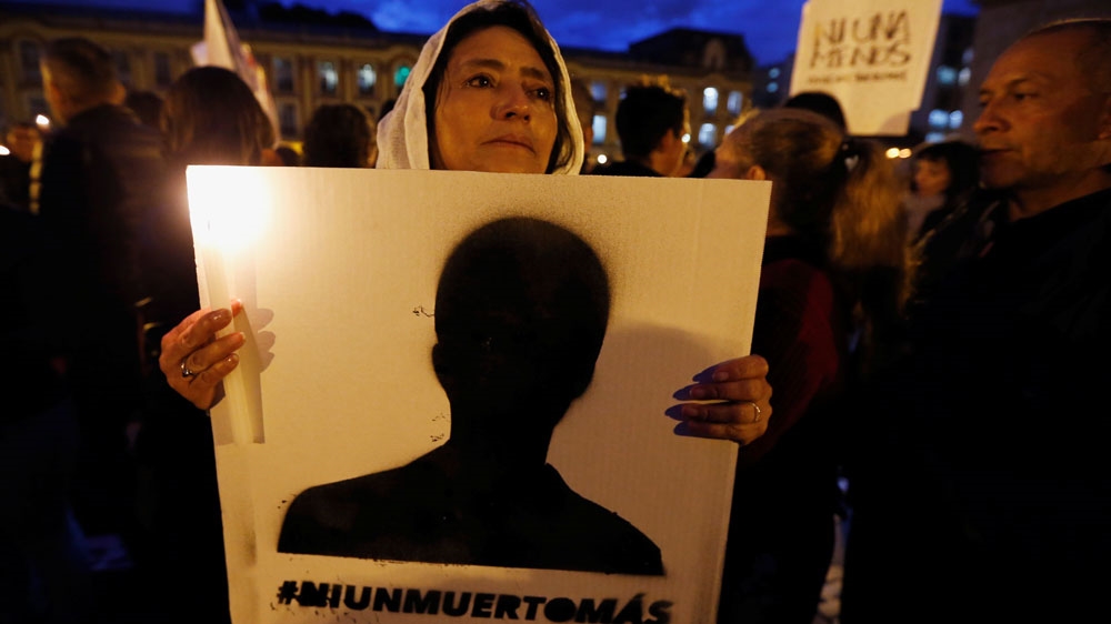 A woman holds a placard that reads 'No one more death' as she takes part in a protest against the killing of social activists [File: Luisa Gonzalez/Reuters] 