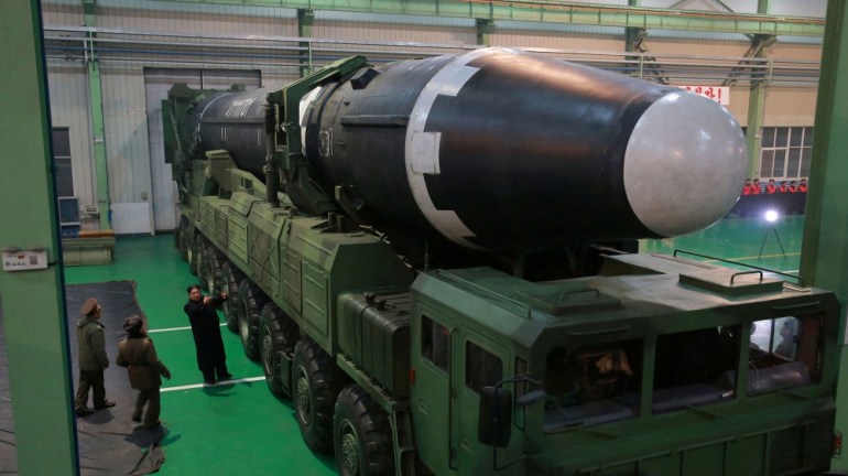 North Korea Hwasong-15 missile on a transporter with Kim Jong Un looking on.