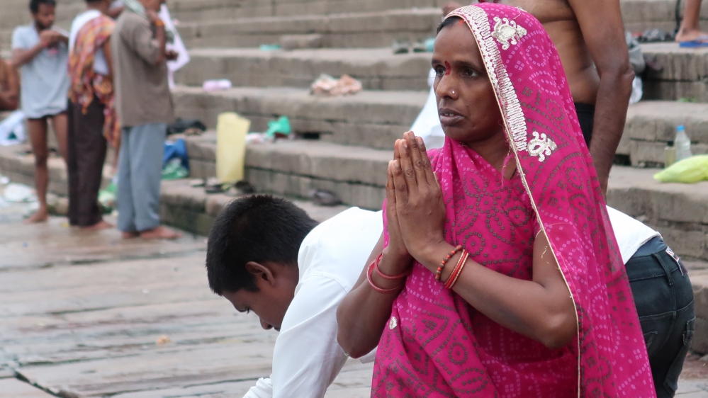 Worshippers perform early morning prayers along the banks of the holy Ganges River in Varanasi [Karishma Vyas/Al Jazeera]
