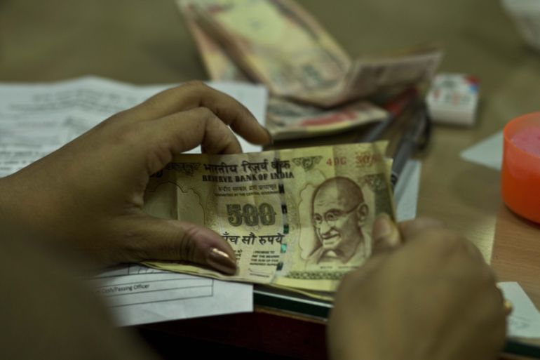 Close-up of an Indian bank official's hands as they count discontinued five hundred rupee notes in Gauhati, India.