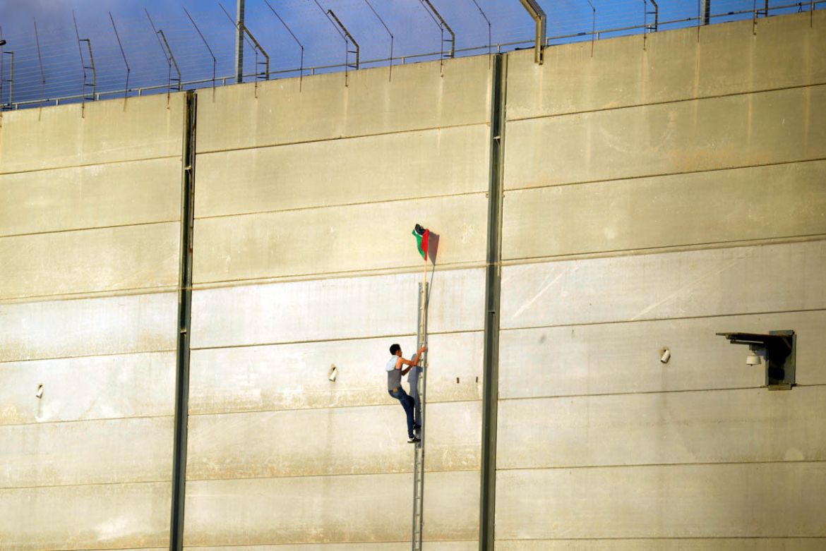 Palestinians climbs the outer wall of the ''Karni'' crossing, east of Gaza City, July 21, 2018.