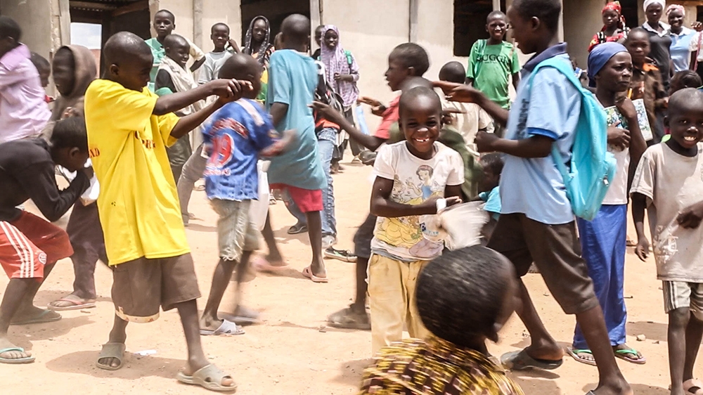 Children play 'Boko Haram versus soja' in a school field in Yola, Nigeria [Chika Oduah/Al Jazeera]