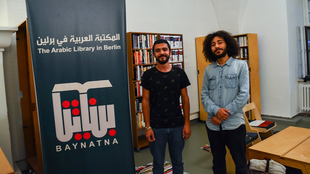 'We have been coming to the library since it opened', says Jwan (left) who is a volunteer. Omar (right) teaches Arabic to children and does language exchange classes with German students [Marta Vidal/Al Jazeera]