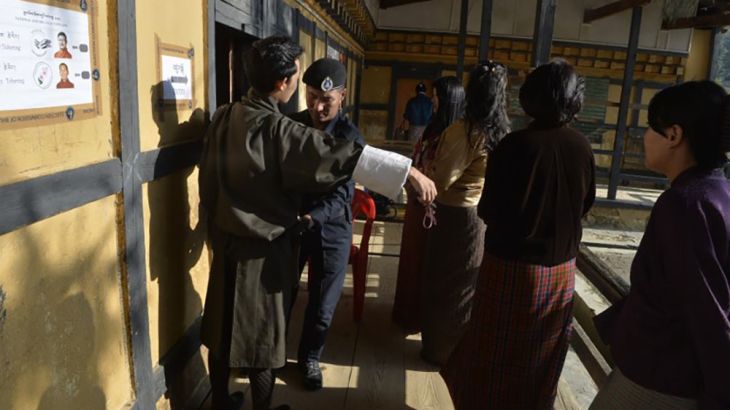 A Bhutanese voter is searched as others line up to cast their ballots at a polling station in Babesa on the outskirts of Thimpu, the capital of Bhutan, on October 18, 2018. Bhutan is set to get a new