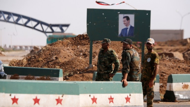 Syrian soldiers stand at the Nasib border crossing with Jordan in Deraa