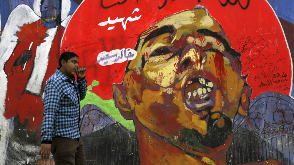 An Egyptian boy passes by a mural of Khaled Said's post-mortem photo in downtown Cairo on November 29, 2012 [Reuters/Amr Abdallah Dalsh]
