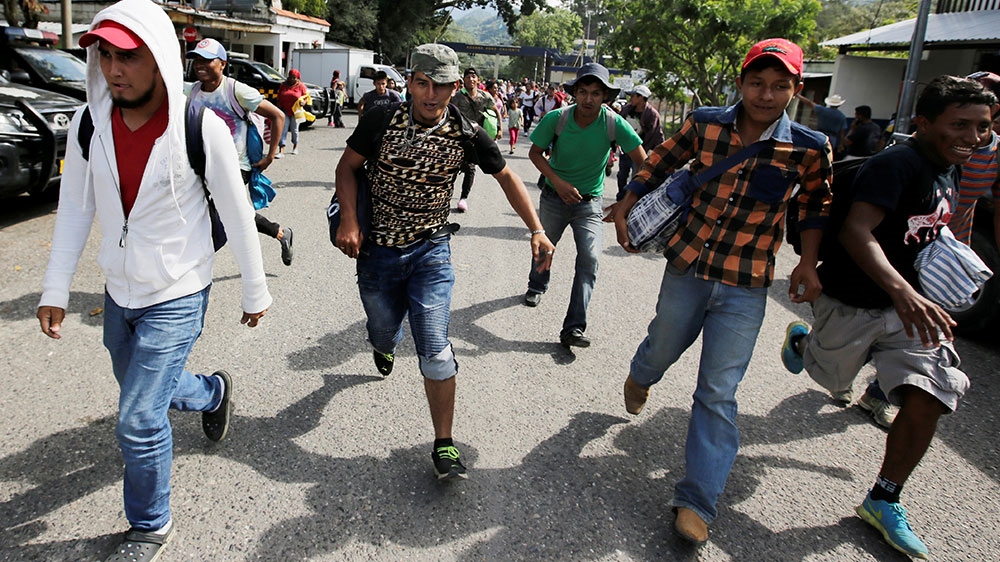 Honduran migrants, part of a caravan trying to reach the US, run after crossing the border between Honduras and Guatemala [Jorge Cabrera/Reuters] 