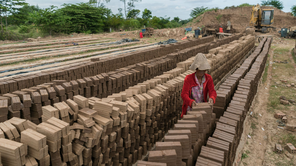 Kiln Nakry stacks fired bricks outside the kiln to dry before they are sold to construction sites [Thomas Cristofoletti/Royal Holloway]