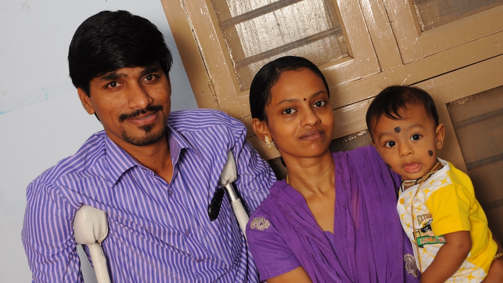 KR Raja, with his wife and child outside his home in Madurai, India [Global Network for Equality]