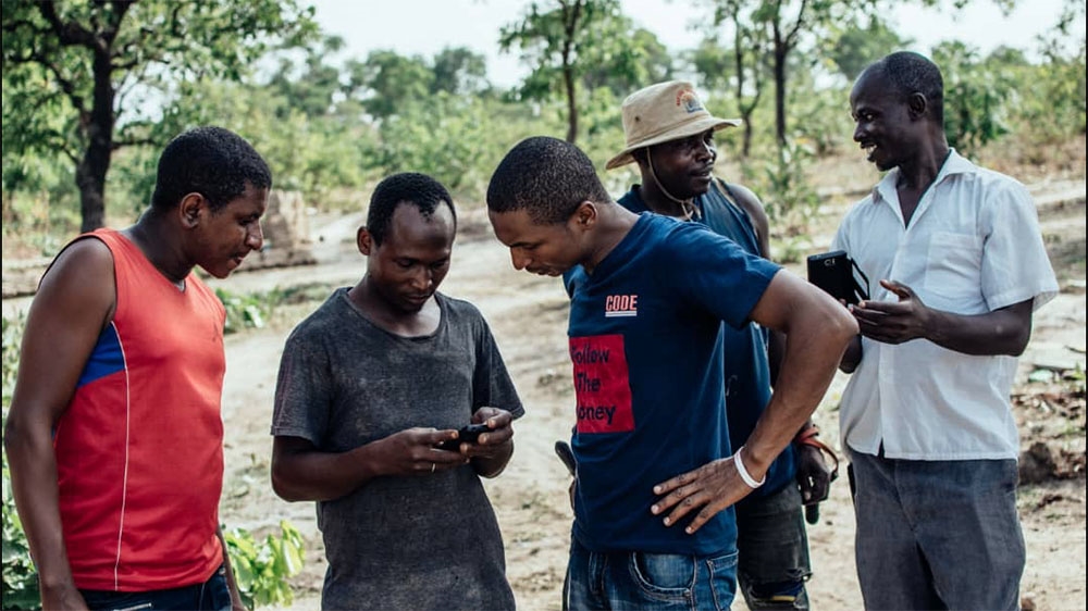 Hamzat Lawal of CODE teaches miners in Niger state how to access information on their mobile phones [Courtesy: CODE]