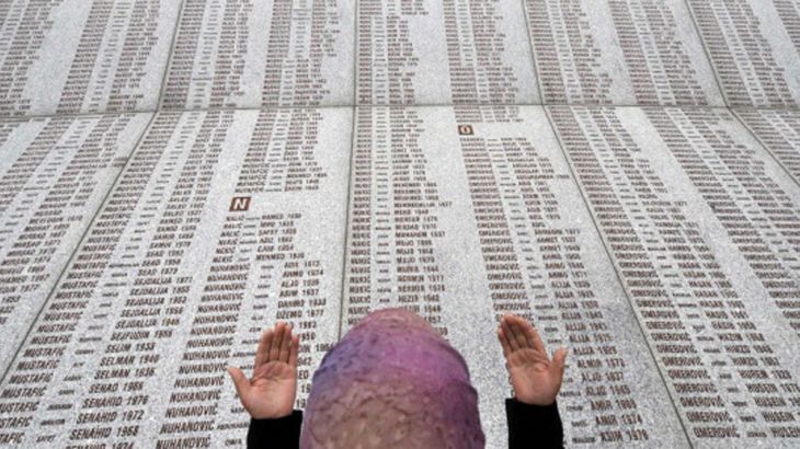 A Bosnian Muslim woman prays at the memo A Bosnian Muslim woman prays at the memorial wall with the names of the victims at the Potocari Memorial Center near Srebrenica on July 22, 2008.