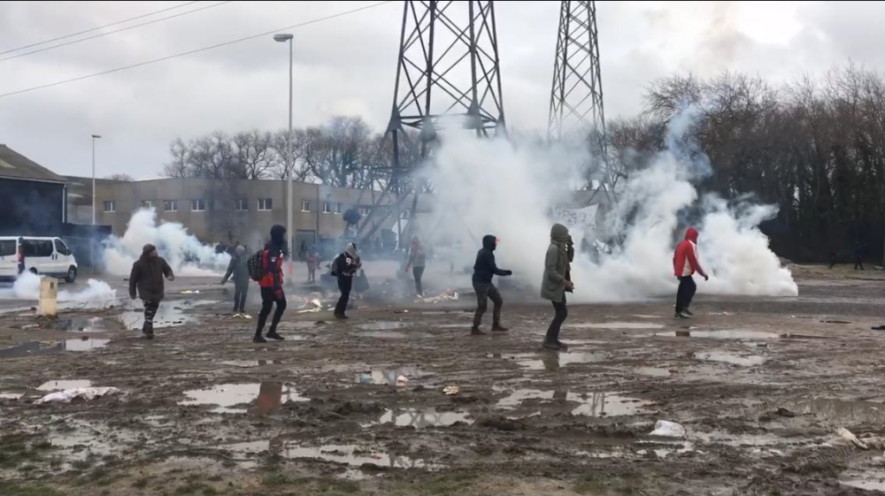 Refugees run and cover their faces after French police fire tear gas in Calais [Courtesy: L'Auberge des Migrants, Refugee Info Bus, Utopia56 and Legal Shelter]