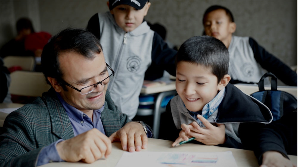 Uighur-Muslim scholar Abduweli Ayup volunteers his time to teach the Uighur language and culture to children who have fled Xinjiang with their families [Steve Chao/Al Jazeera]