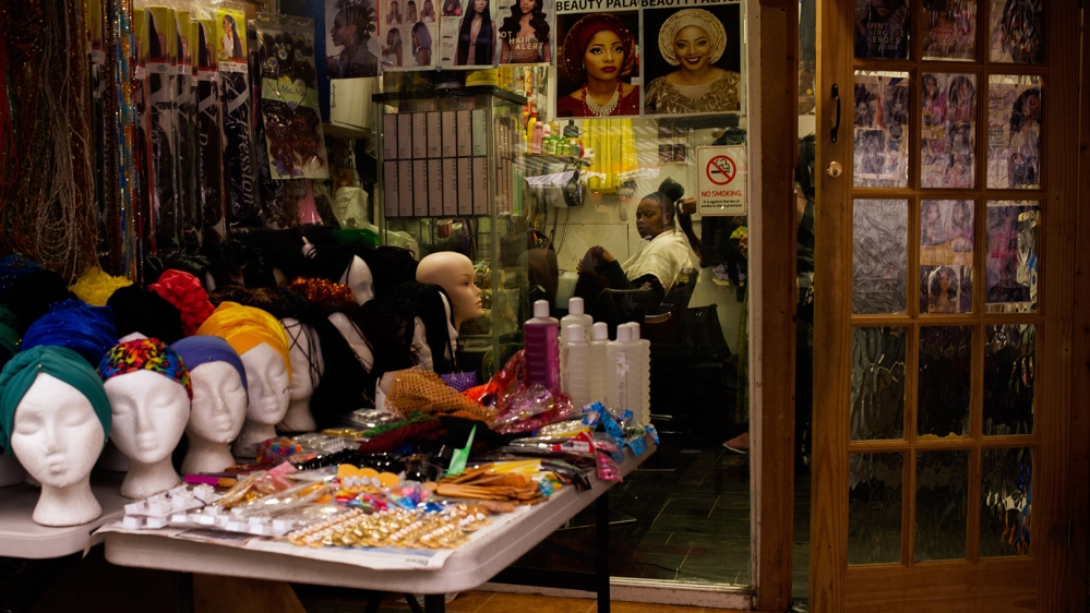 A customer in one of the many hairdressers along Ridley Road market [Jose Sarmento Matos/Al Jazeera]