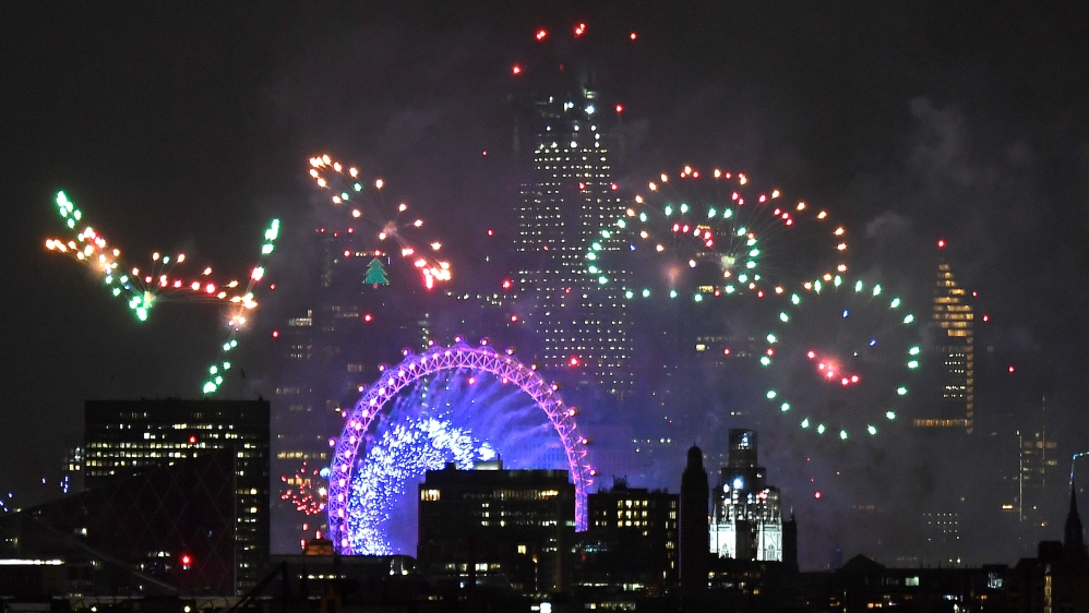 Fireworks light up the sky around the London Eye wheel to welcome the New Year in the UK capital [Toby Melville/Reuters]