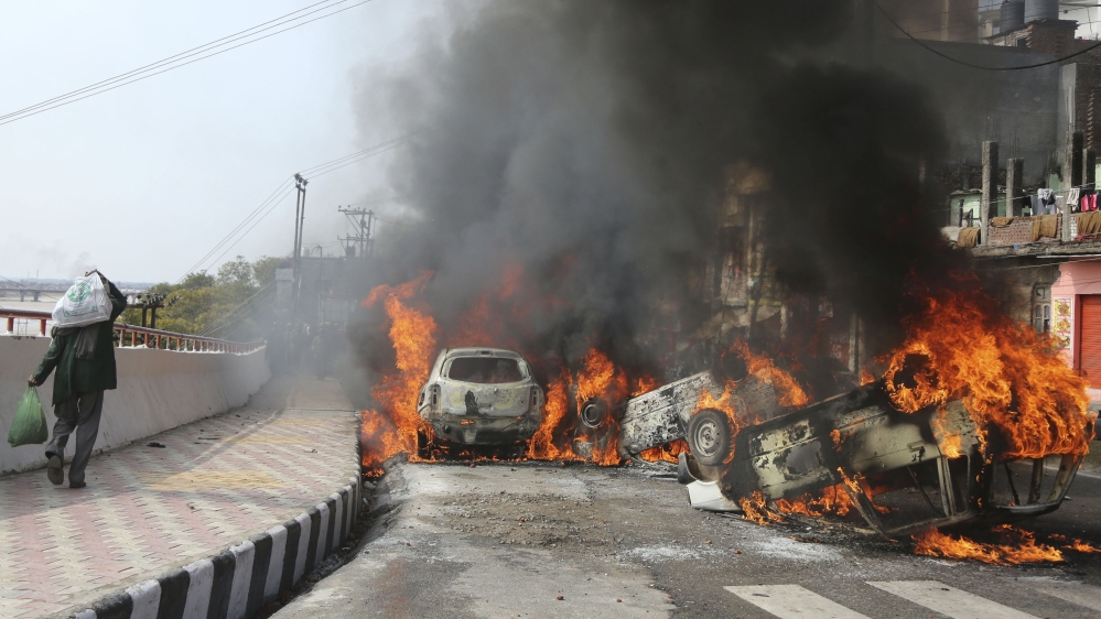 Protesters in Jammu set fire to vehicles, prompting authorities to declare a curfew [Channi Anand/AP]