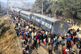 Rescue workers look for survivors as locals stand around the derailed coaches of a train , 30 kilometers (20 miles) north of Patna, the Bihar state capital of India, Sunday, Feb. 3, 2019. Seven coache