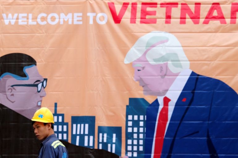 A man walks past a banner depicting North Korean leader Kim Jong Un and U.S. President Donald Trump ahead of the North Korea-U.S. summit in Hanoi
