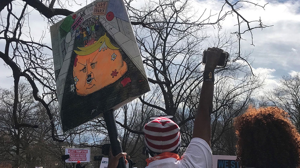 Protesters outside the White House rally against Trump's national emergency deceleration on February 18, 2019. [Ola Salem/Al Jazeera]