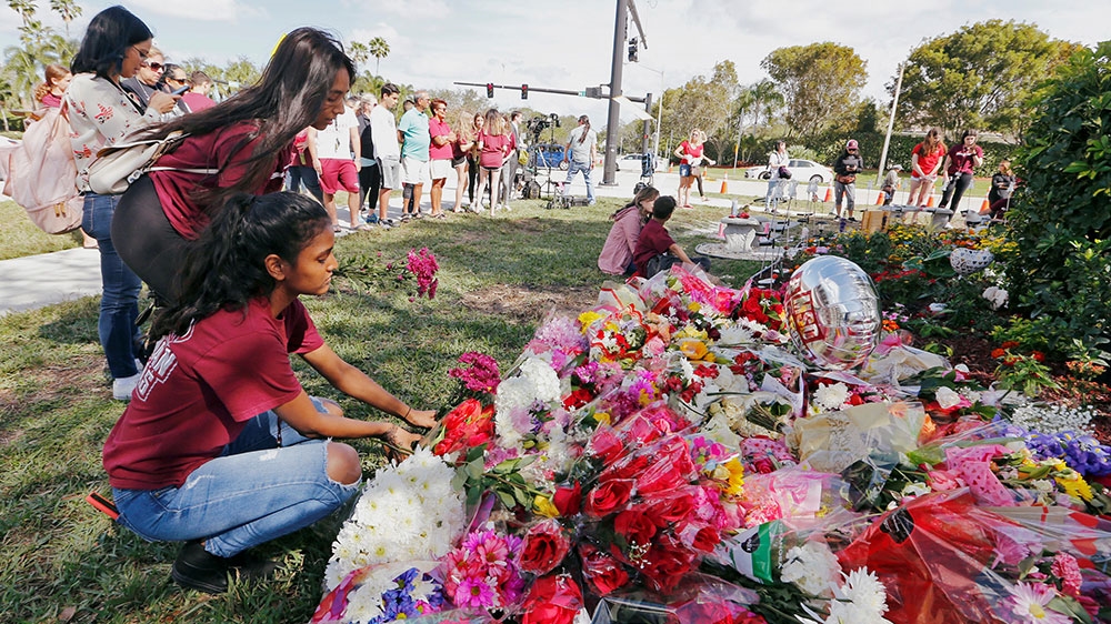 Bouquets are placed at a memorial on campus on the one-year anniversary of the shooting which claimed 17 lives at Marjory Stoneman Douglas High School in Parkland, Florida [Joe Skipper/Reuters] 