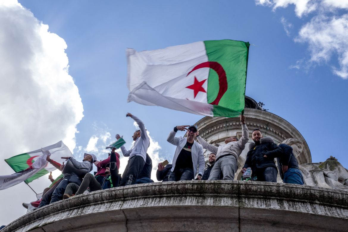 A group of Algerian protesters stand on top of the Monument ‡ la RE`publique during a demonstration against Algerian President Abdelaziz Bouteflika in Place de la RE`publique in Paris, France. Photo b