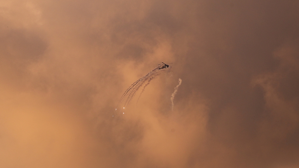 
An Israeli Apache helicopter releases flares as it flies over the Gaza Strip [Mohammed Salem/Reuters]
