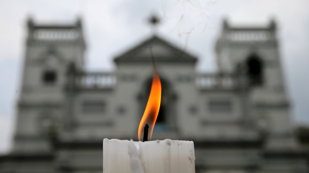 A candle burns outside St. Anthony's Shrine a week after the suicide attacks [Thomas Peter/Reuters]