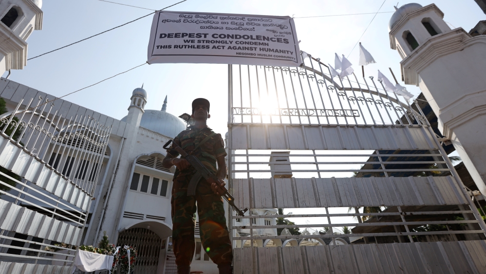 A member of the Civil Defence Force keeps watch outside Negombo Grand Mosque [Athit Perawongmetha/Reuters]