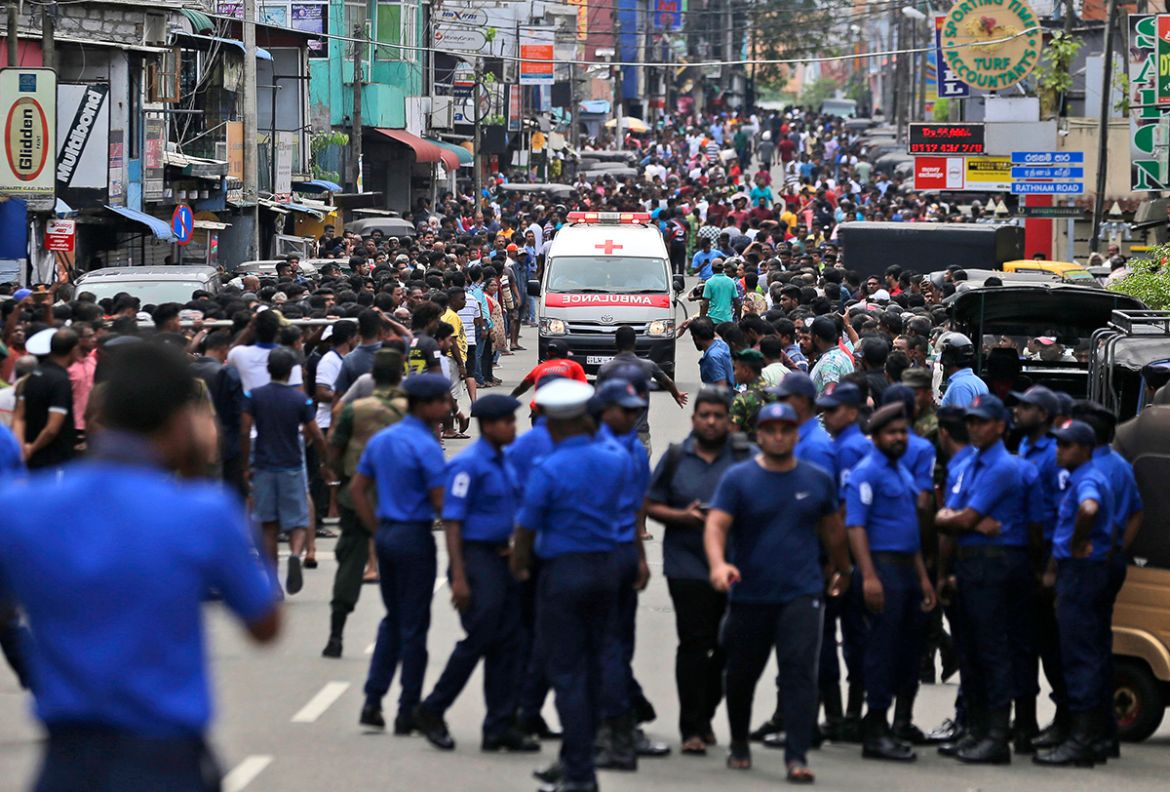 Sri Lankan police officers clear the road as an ambulance drives through carrying injured of Church blasts in Colombo, Sri Lanka, Sunday, April 21, 2019. A Sri Lanka hospital spokesman says several bl