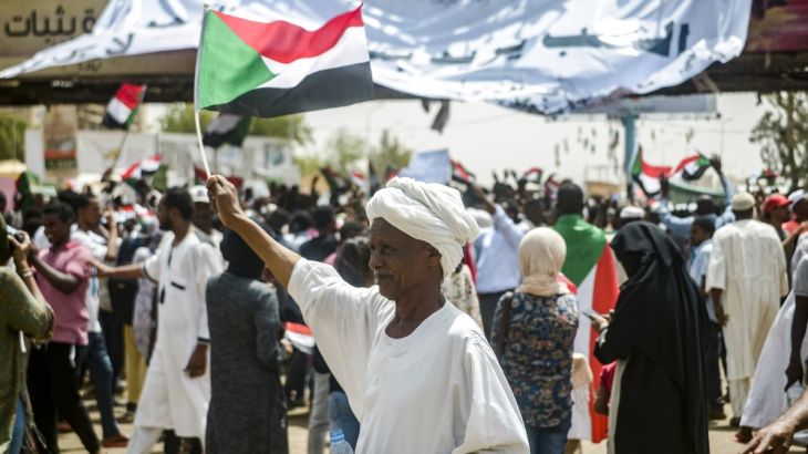 A Sudanese man waves a national flag during a rally demanding a civilian body to lead the transition to democracy, outside the army headquarters in the Sudanese capital Khartoum on April 12